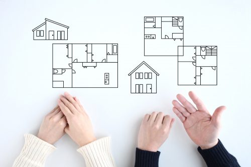 マイホームの間取りや二階建て住宅にするか平屋住宅にするかを話し合う夫婦のイメージ画像