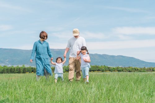 草原を歩く家族・ファミリー(子供・両親・移住・田舎暮らし)