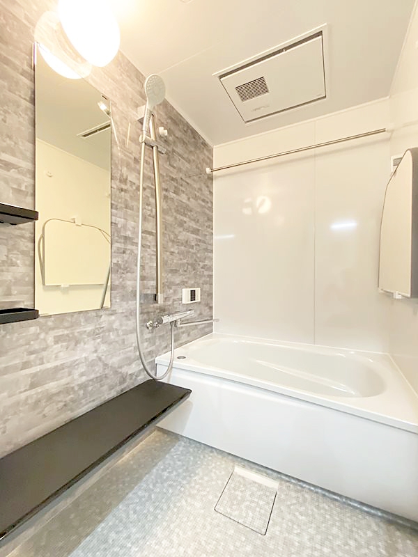 落ち着いた色味の石目調アクセント壁とラグ調の床を採用することで、洗練された雰囲気とホテルライクな明るさを両立。